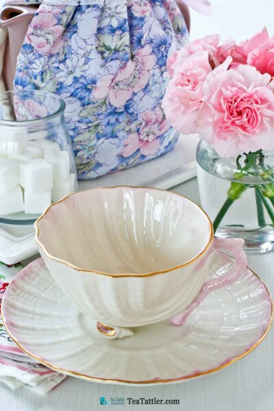 Neptune Seashell, Belleek - a delicate soft pink scooped shell teacup with two tiny conch shell feet and sculptured coral handle. | TeaTattler.com #neptuneseashellteacup #belleek