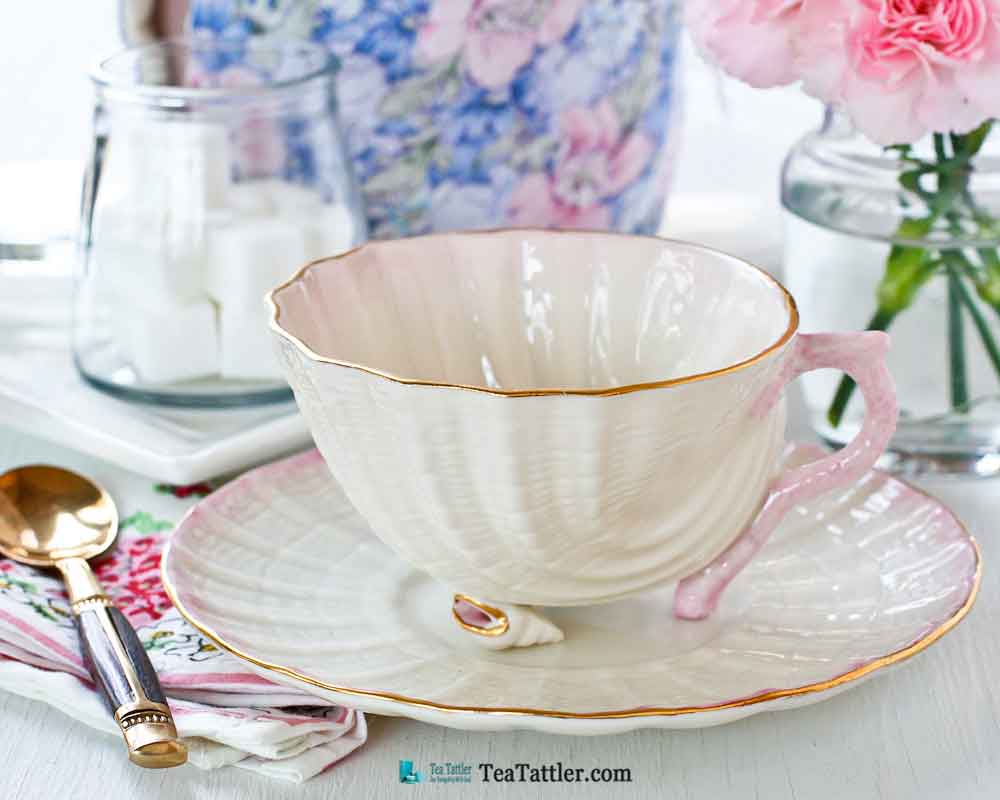 Neptune Seashell, Belleek - a delicate soft pink scooped shell teacup with two tiny conch shell feet and sculptured coral handle. | TeaTattler.com #neptuneseashellteacup #belleek