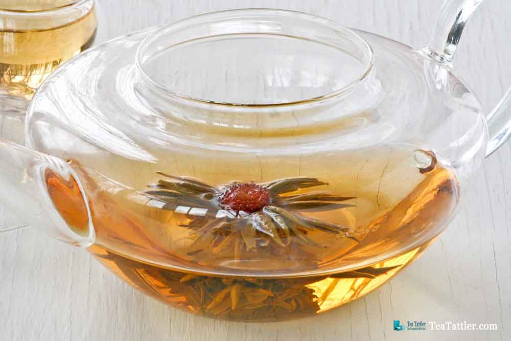 1000 Day Flower Tea is a hand tied tea ball with amaranth blossom in the center. It has a pale golden infusion and light floral notes. | TeaTattler.com #floweringtea #bloomingtea #greentea