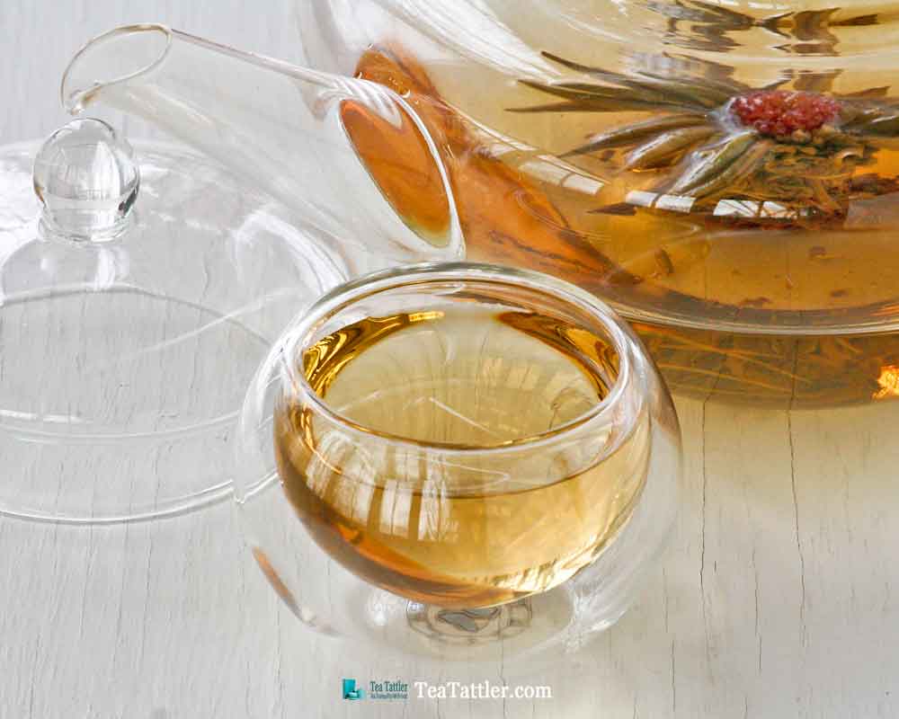 1000 Day Flower Tea is a hand tied tea ball with amaranth blossom in the center. It has a pale golden infusion and light floral notes. | TeaTattler.com #floweringtea #bloomingtea #greentea